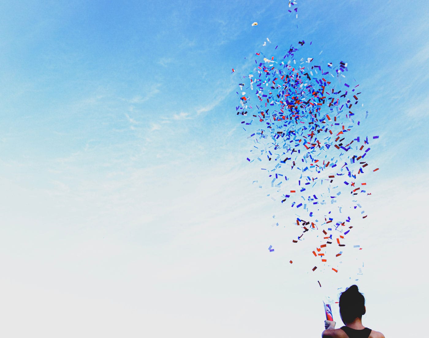 Confetti bursting into a blue sky