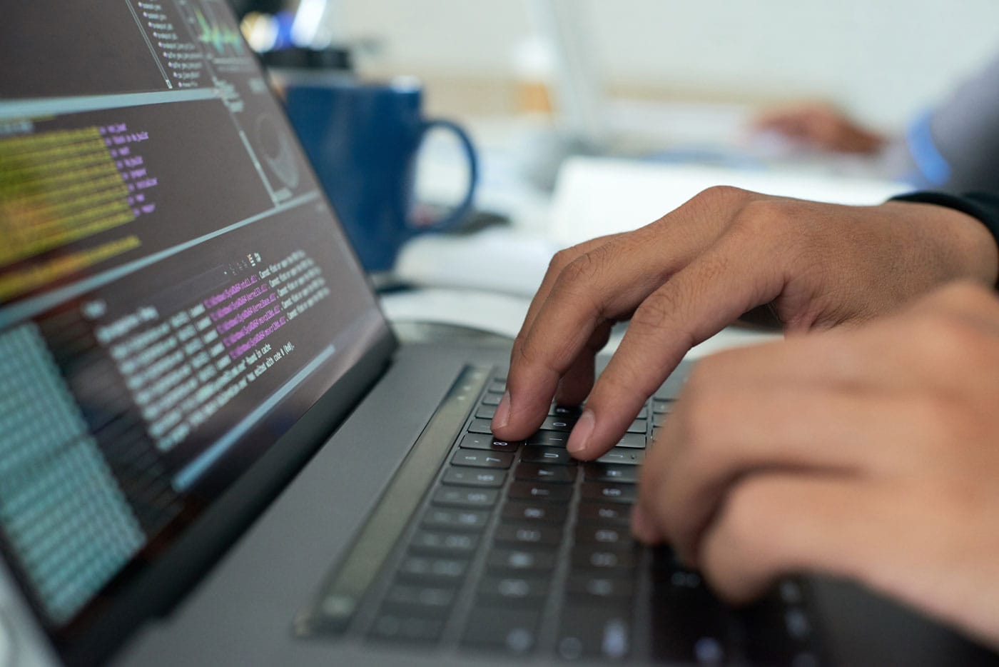 Developer writing code on a laptop